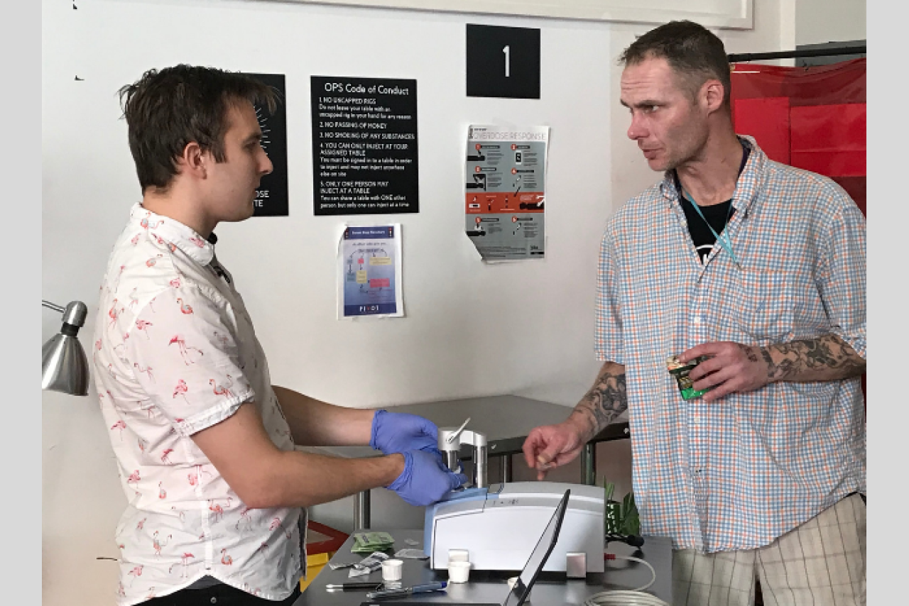 VCH drug checking technician Jeremy Kalicum and PHS peer supervisor Daniel Beaverstock check a sample with the new spectrometer. 