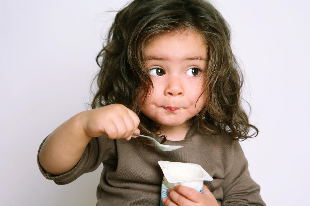A young child eating yogurt.