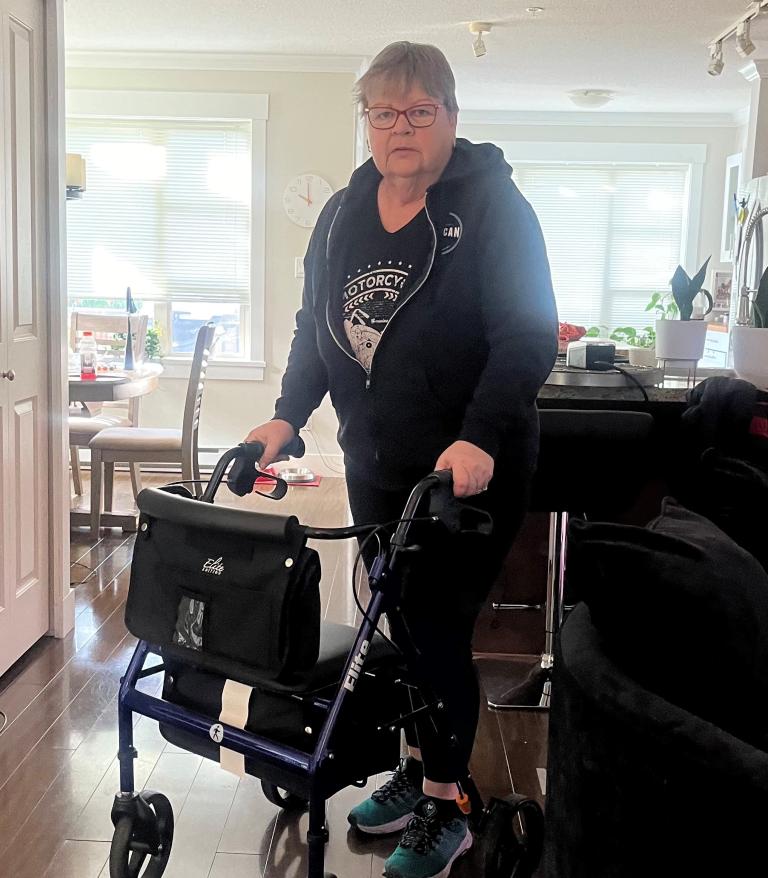Bridget Haley poses for a photo with her walker in her home