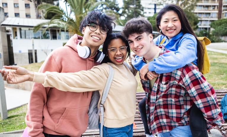 Group of teens smiling for a photo outside