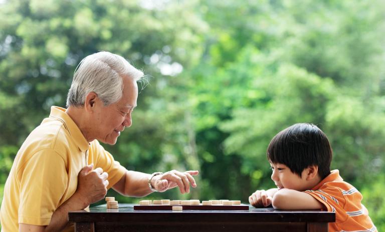 Grandfather and grandson playing Xiangqi
