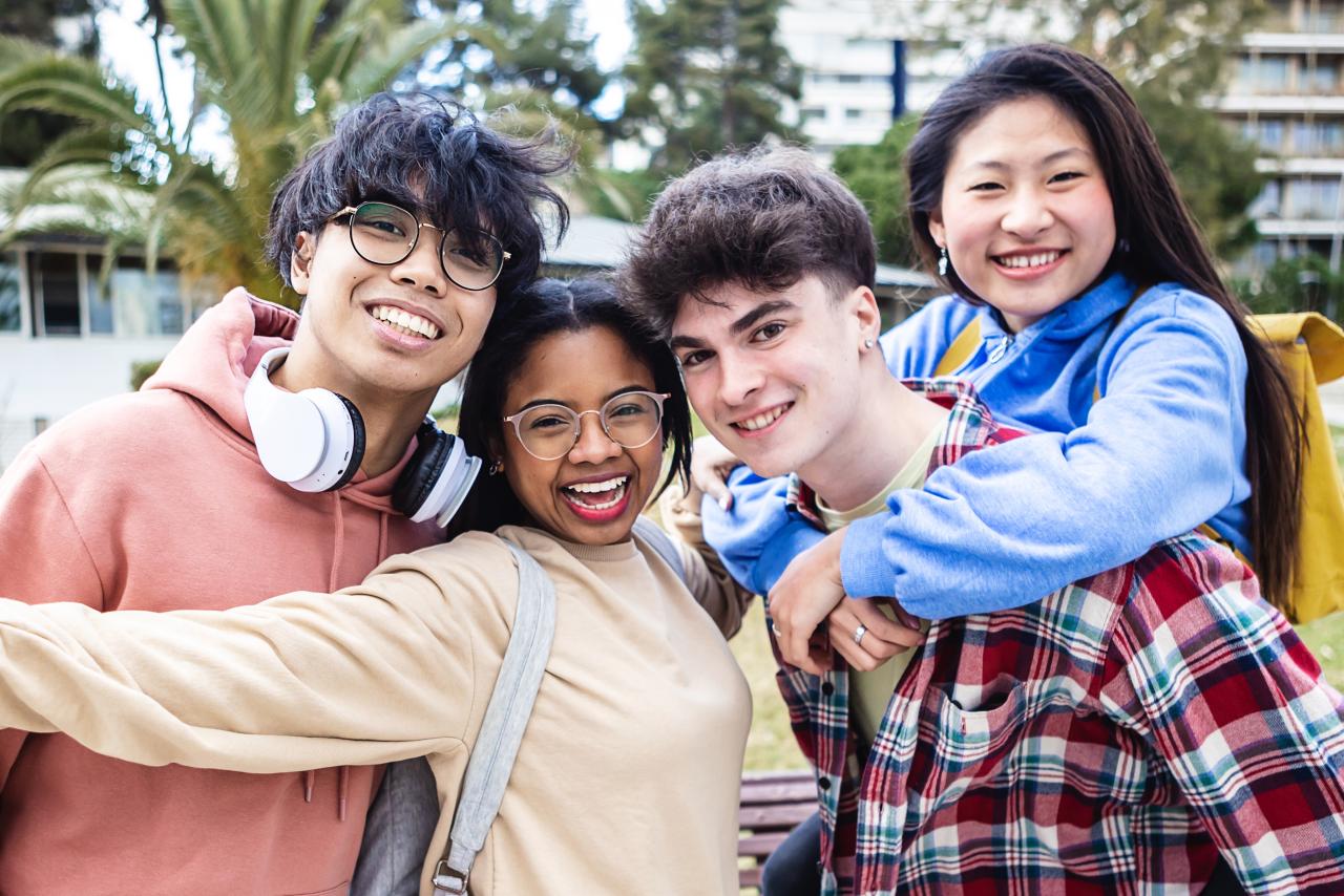 Group of teens smiling for a photo outside