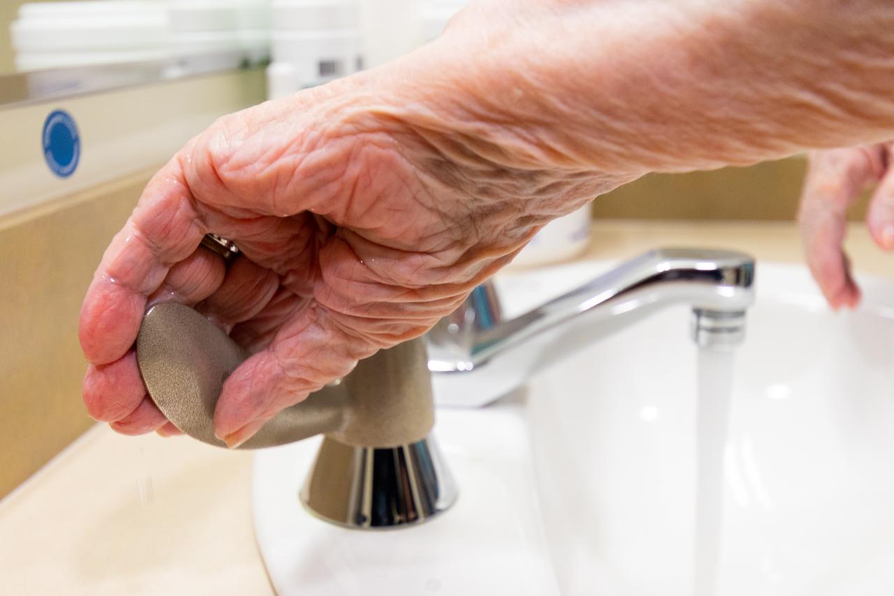 Hand of resident at a VCH facility turning on the antimicrobial copper faucet.