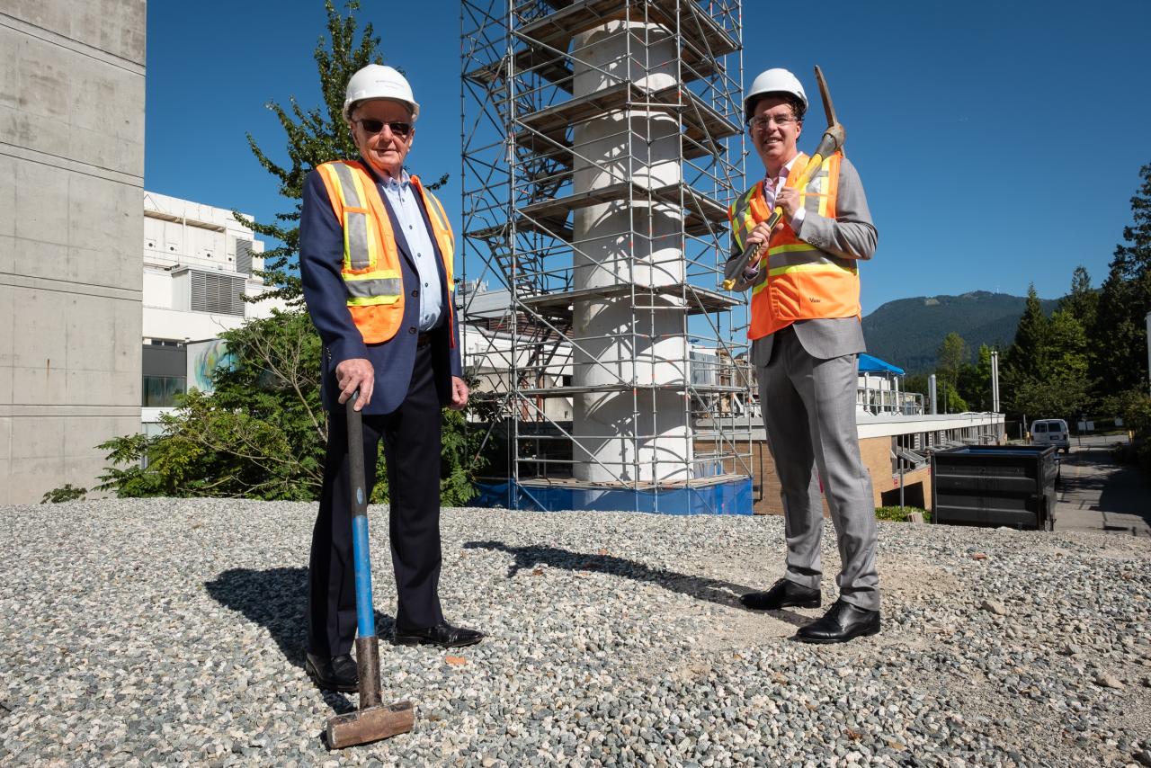 Paul Myers and Ryan Beedie standing in front of old power plant stack at Lions Gate Hospital