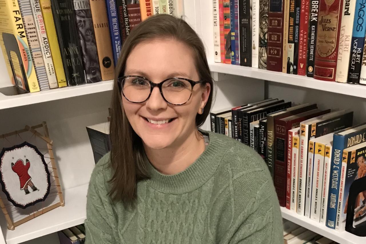 Alyssa Dixon, SLP, sitting in front of a bookshelf.