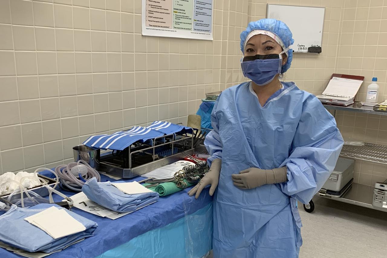 Mary Luu, LPN, standing in an operating room while wearing work scrubs.