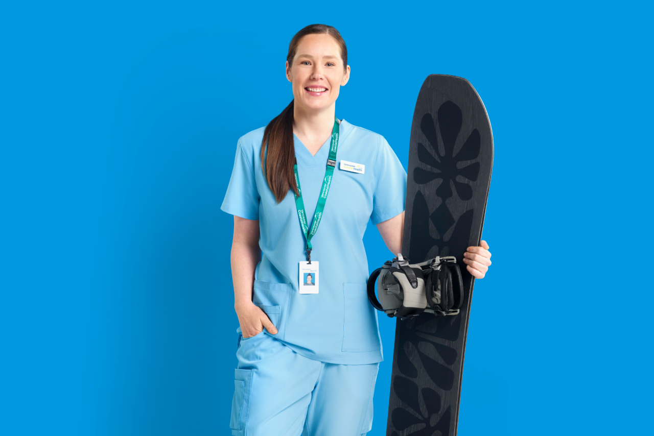 Photo of Siobhan, Registered Nurse, holding a snowboard against a blue background