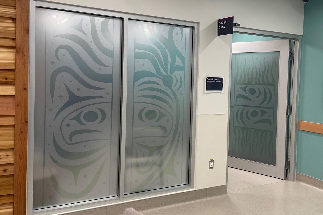 Indigenous artwork mural on top of windows and a door