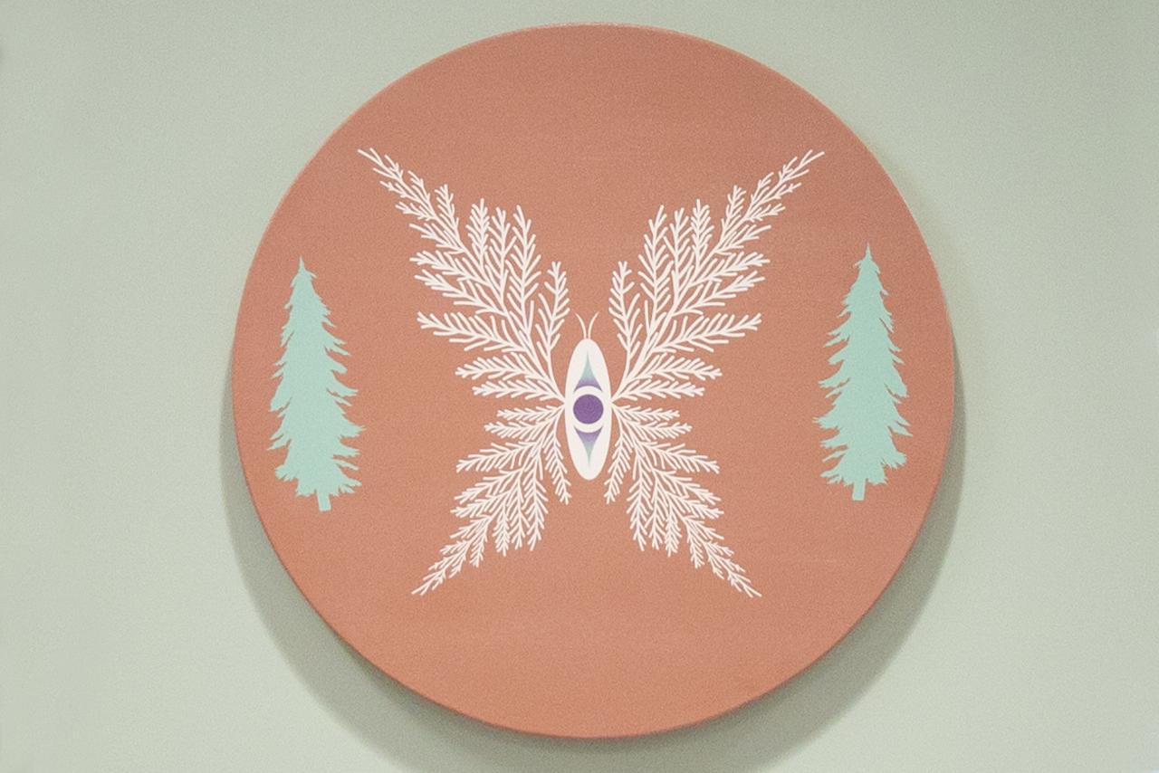 Indigenous artwork of a forest mounted on a white wall 