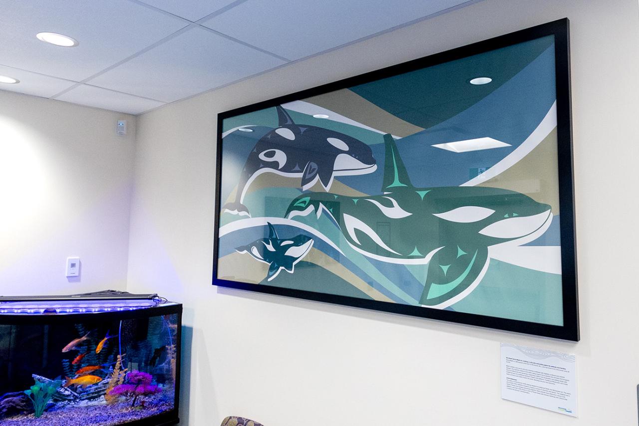 artwork on the wall in an office of three orca whales