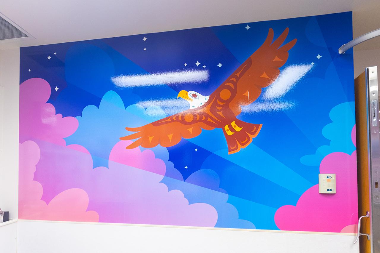 mural of an eagle soaring over pink clouds and blue sky