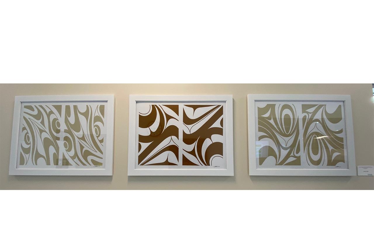 three framed abstract prints in a row on a wall
