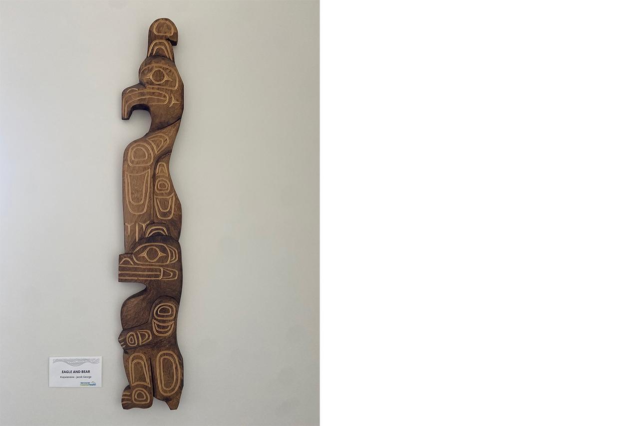 Indigenous wooden carving mounted on a white wall 