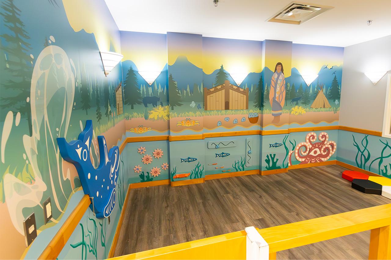 Indigenous mural of a forest and sea on a wall with interactive animals 