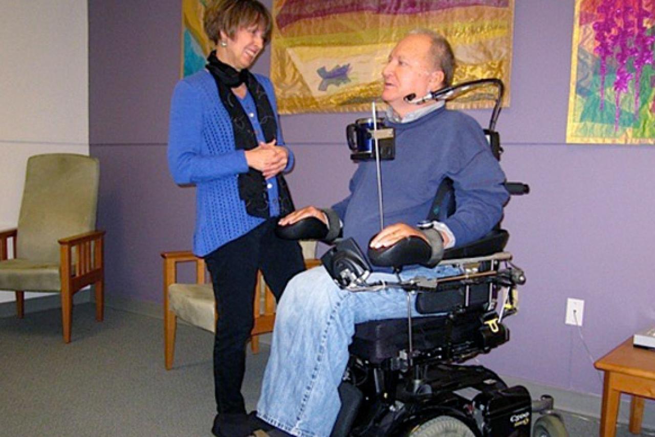 A man in a wheelchair speaking to a woman inside