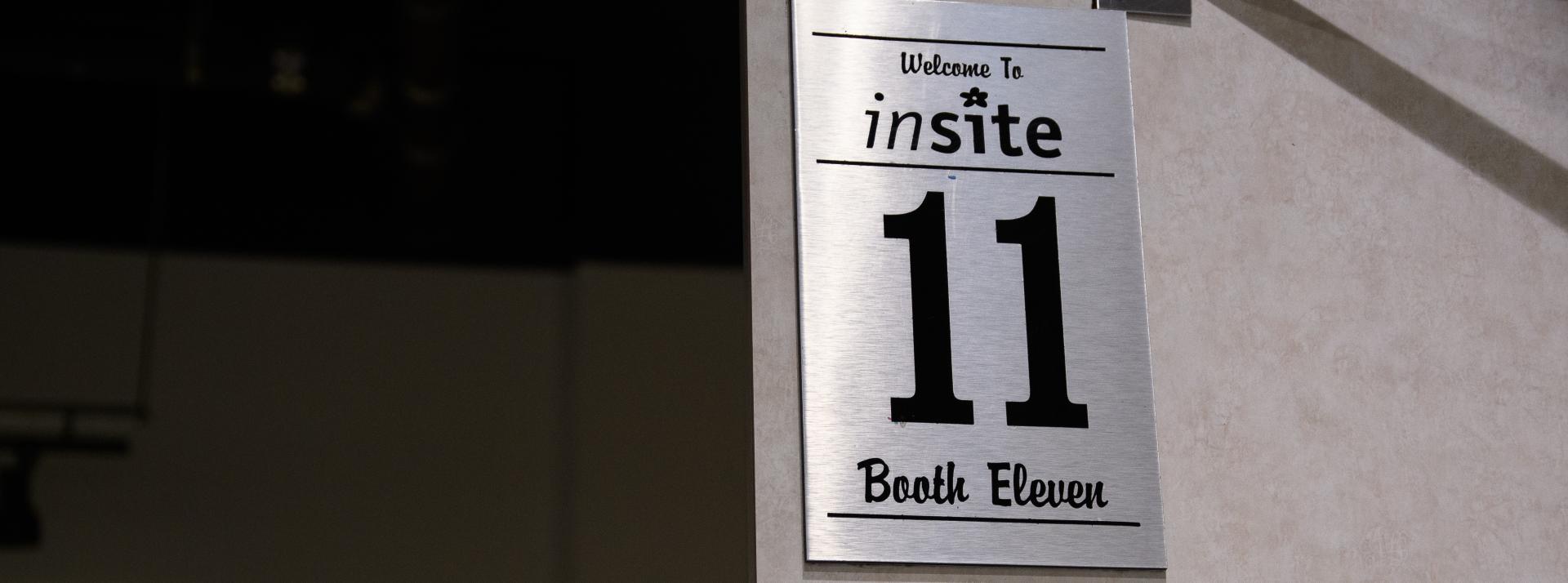 A silver sign that says Welcome to Insite booth 11
