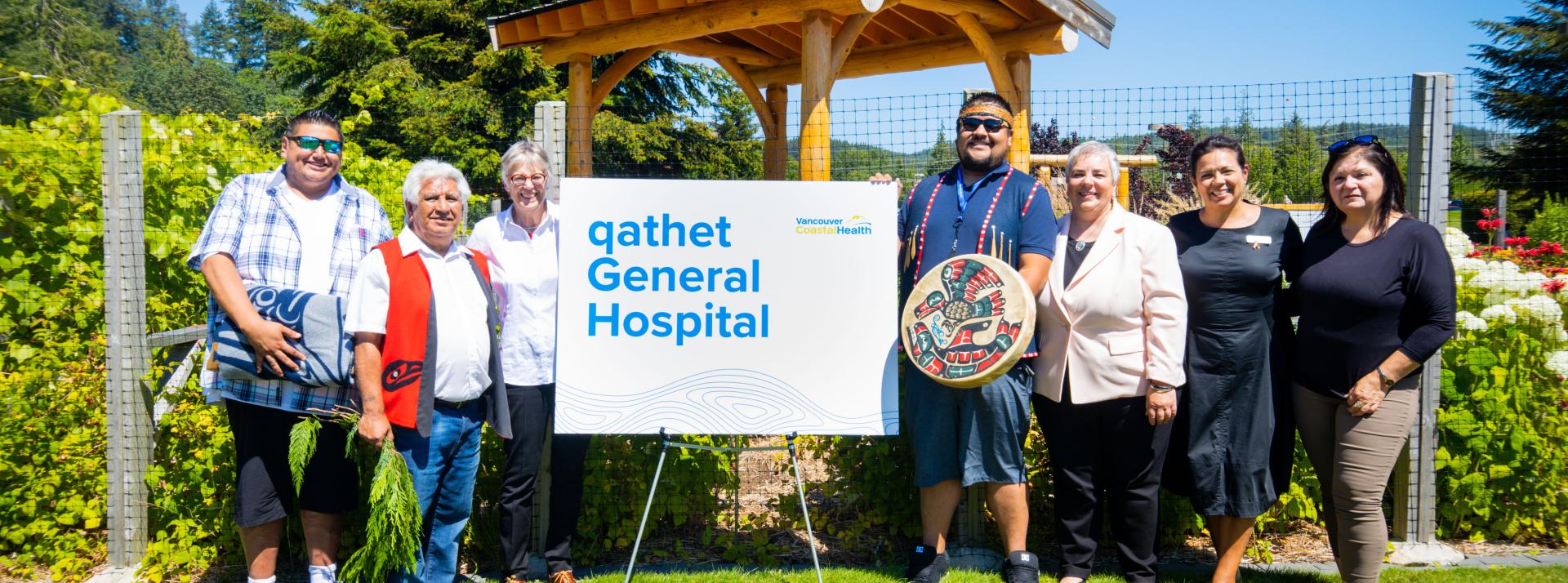 Group of people standing next to qathet General Hospital sign.