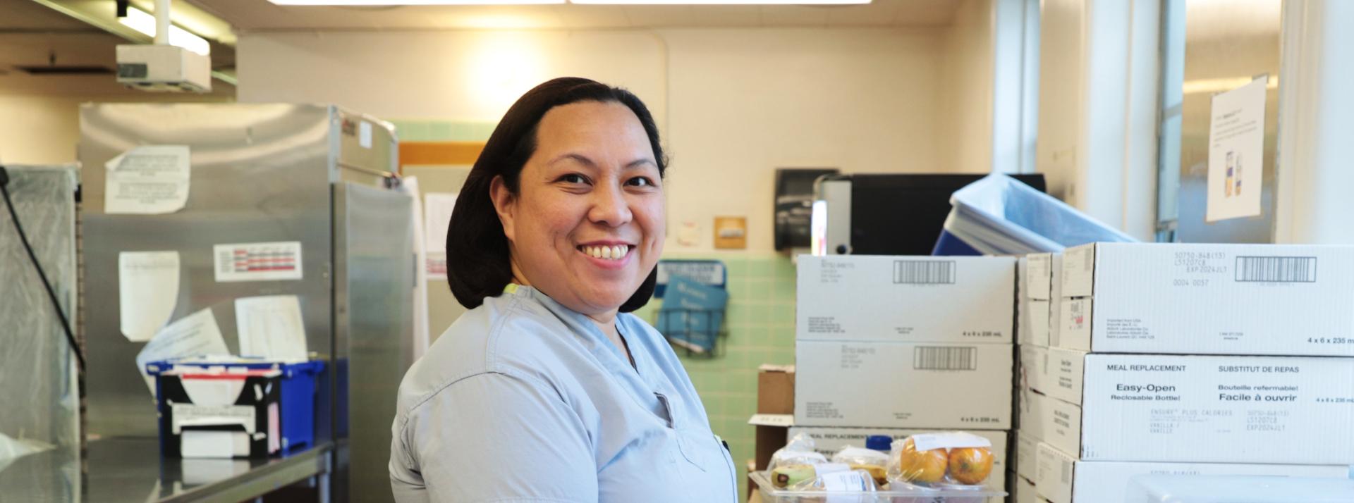 A facilities worker smiling in a kitchen