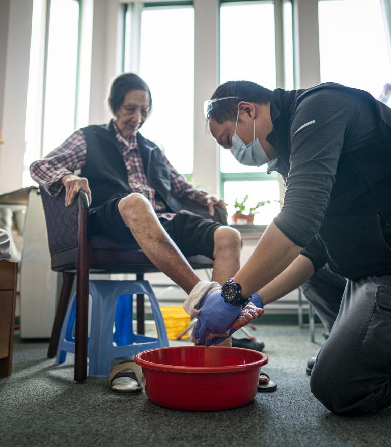 home support worker washes a clients feet