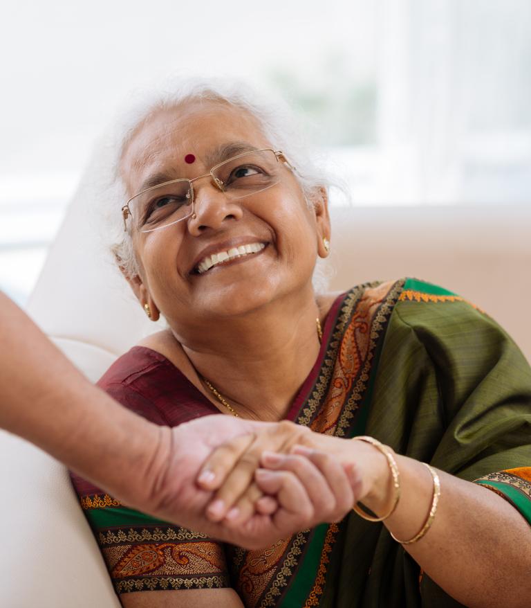 happy senior woman holding the hand of a caretaker
