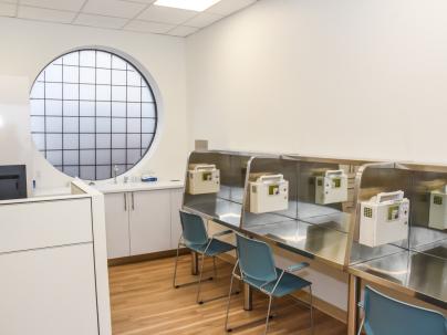Three tables inside the supervised consumption room of Heatley Community Health Centre with a round window in the background