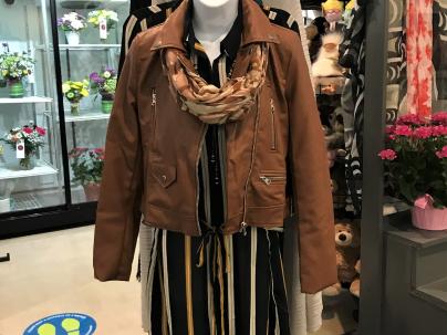 Jacket and scarf on a clothing rack in the VGH gift shop.  A selection of flowers is visible in the background