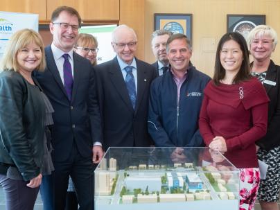 Group of people next to a scale model of the new Lions Gate Hospital acute facility