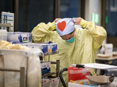person with heart on cap putting on mask