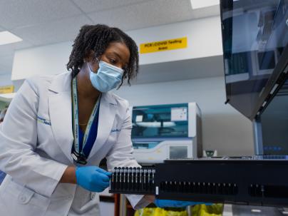 a Medical Microbiologist is interacting with a machine