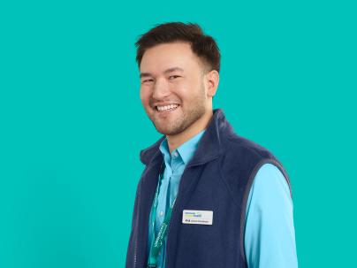 VCH staff member Kyle smiling in front of a teal background