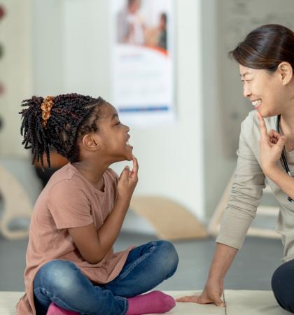 A speech language therapist working with a child.